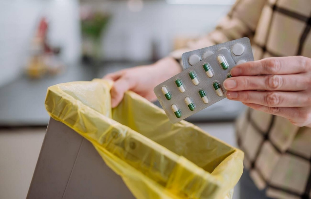 man throwing away pills